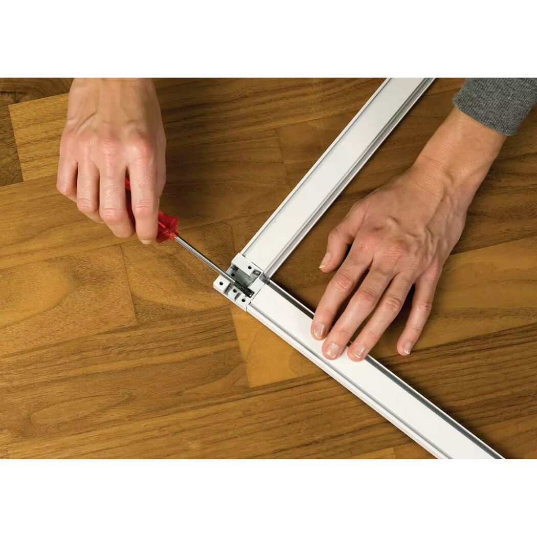 Person montiert Fliegengitter mit einem Schraubenzieher.