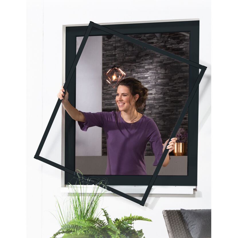 Person bringt Fliegengitter am Fenster an