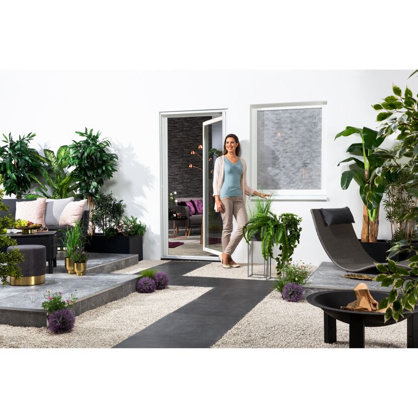 Person im Garten mit Pollenschutzvlies am Fenster