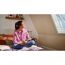 Person liest auf Bett unter Dachfenster mit Plissee