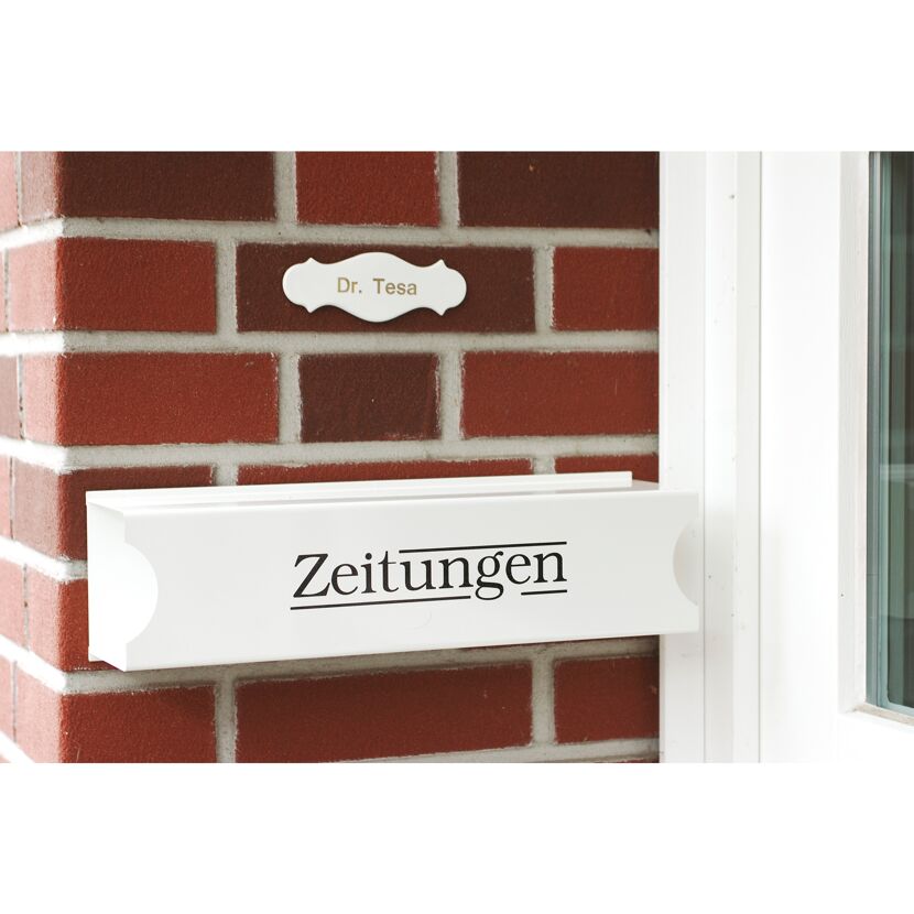 Weißer Zeitungsroller an roter Backsteinwand