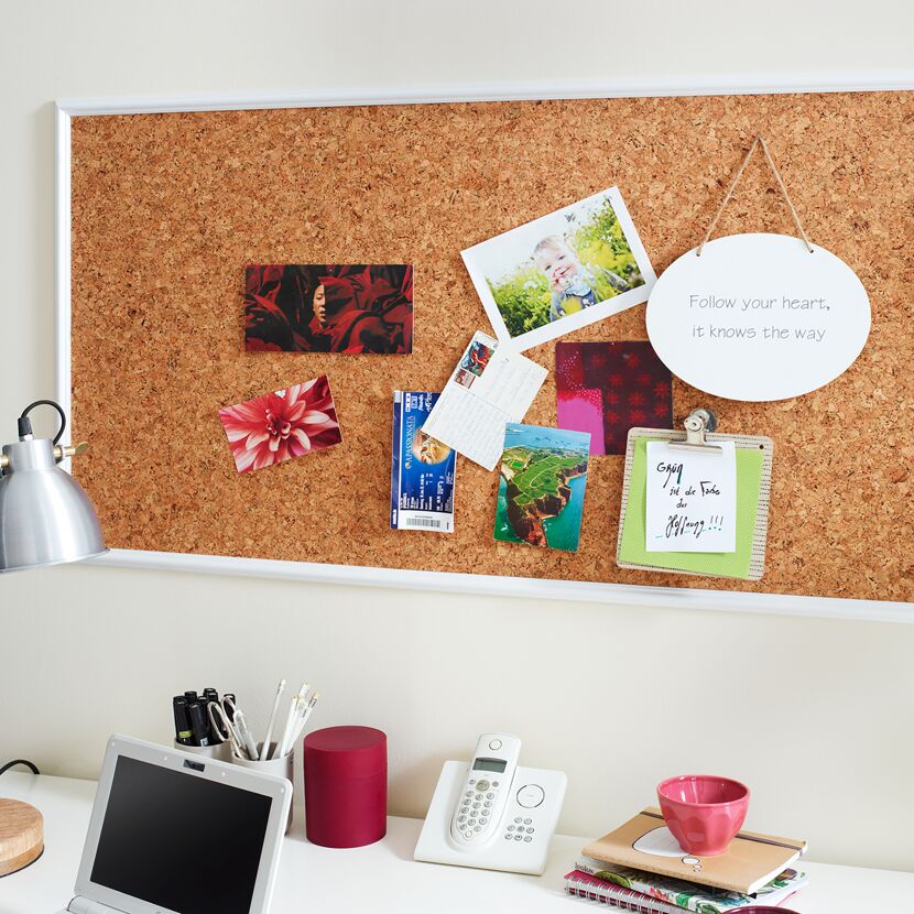 Korktafel mit Fotos, Postkarten und einem inspirierenden Zitat.