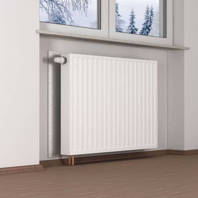 Weißer Heizkörper mit Dämmplatte an der Wand