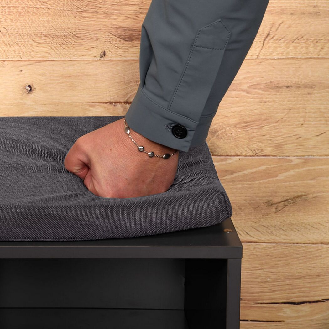 Hand drückt Polsterung eines Schuhschranks