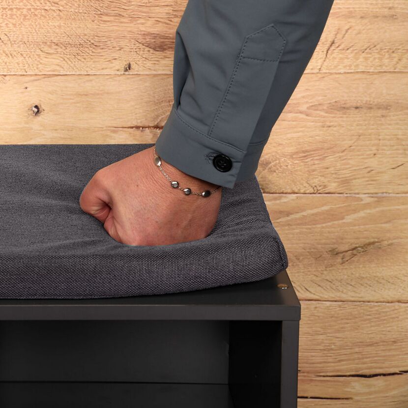 Hand drückt Polsterung eines Schuhschranks