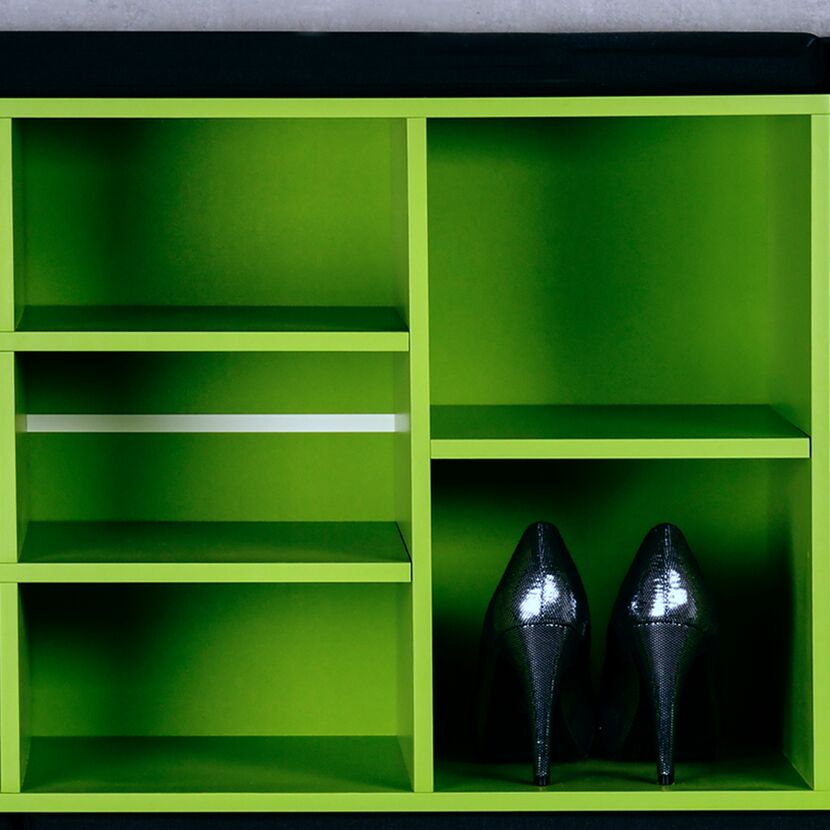 Grünes Schuhregal mit einem Paar schwarzen Schuhen