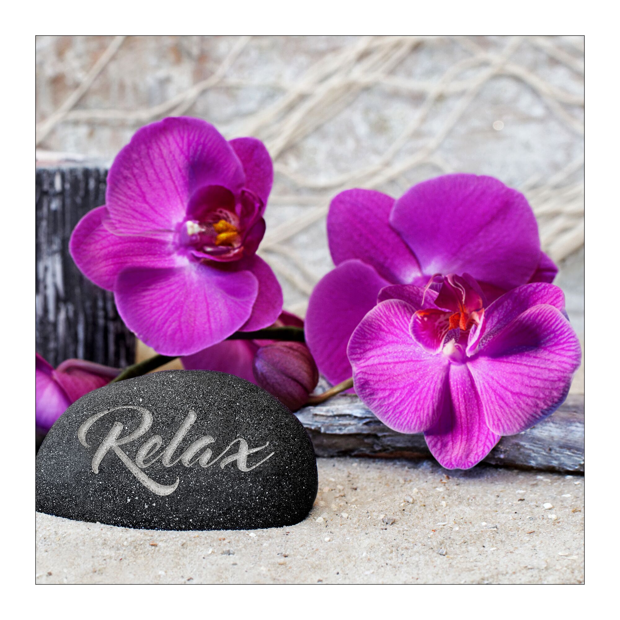 Lila Orchideenblüten und ein Stein mit der Aufschrift "Relax".