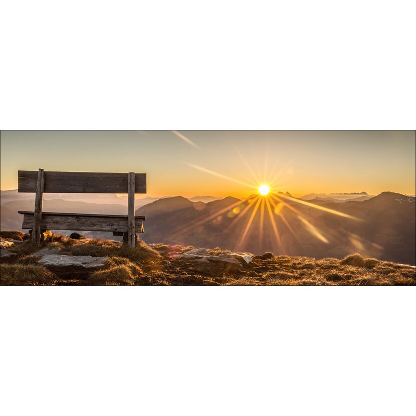 Bank auf einem Hügel bei Sonnenuntergang.