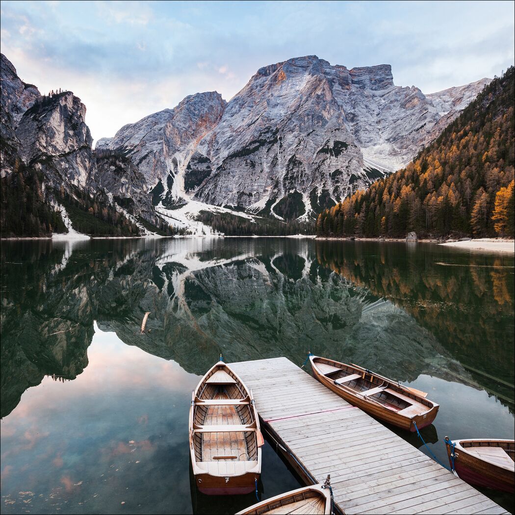 Holzsteg mit Booten auf einem Bergsee