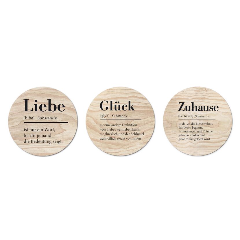 Drei runde Holzscheiben mit den Worten Liebe, Glück und Zuhause.