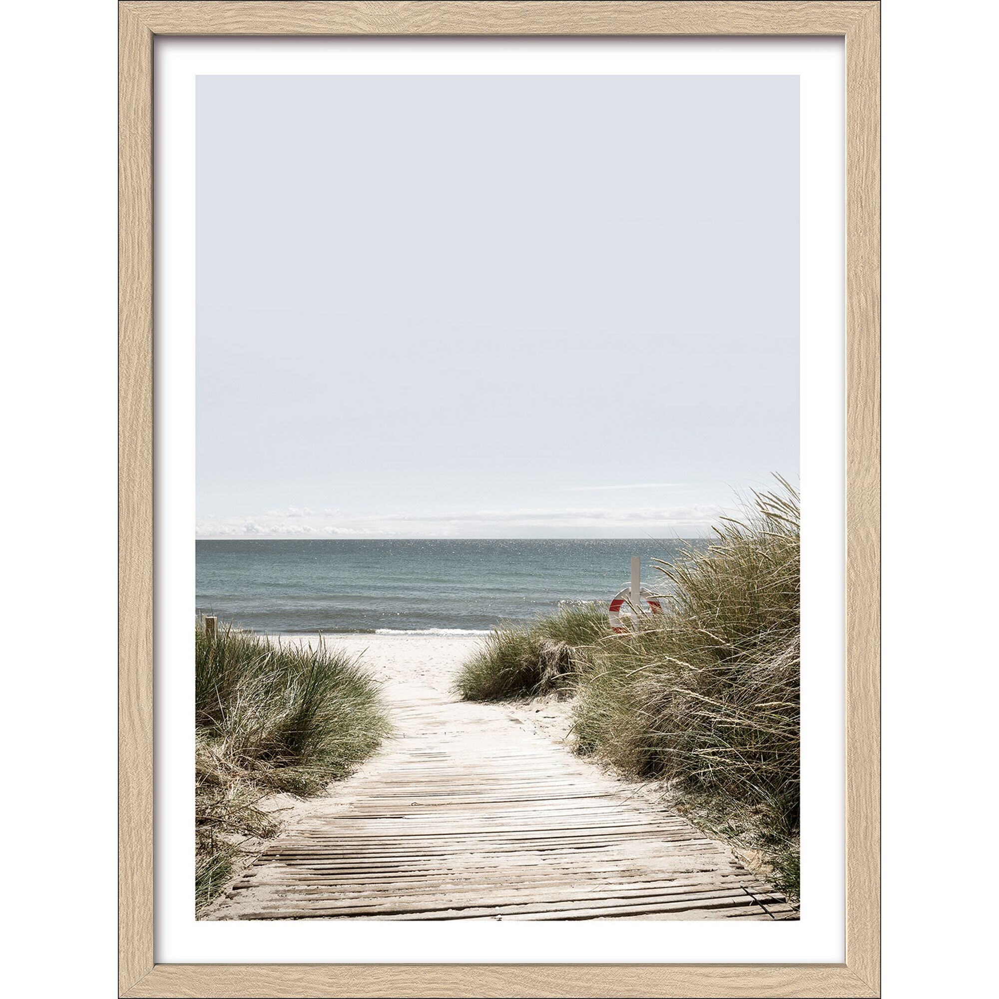 Holzsteg führt durch Dünengras zum Strand.
