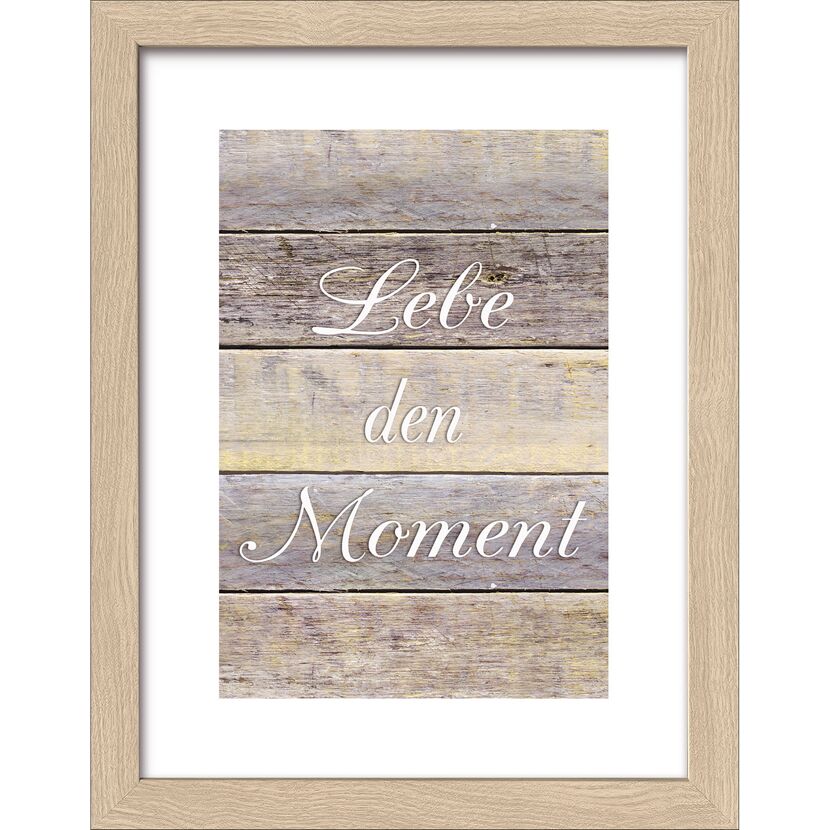 Gerahmtes Bild mit Aufschrift "Lebe den Moment" auf Holzhintergrund.
