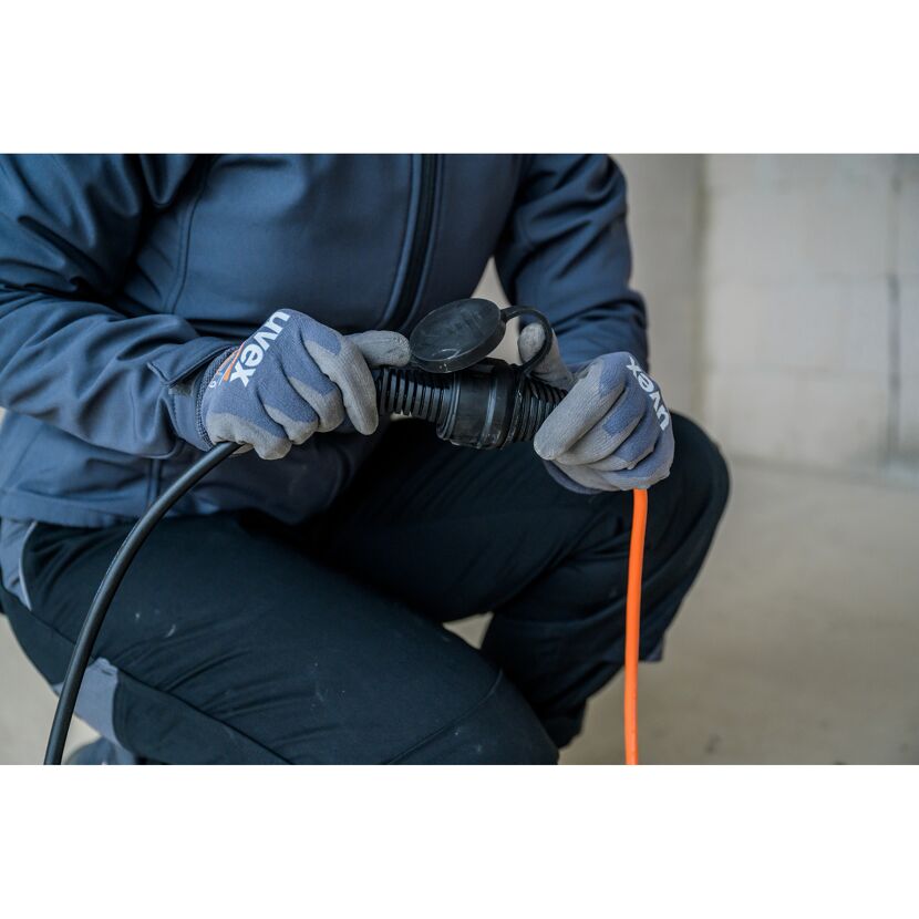 Person hält ein Verlängerungskabel in der Hand.