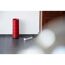 Weiße Steckerleiste mit roter Lampe und Holzschrank