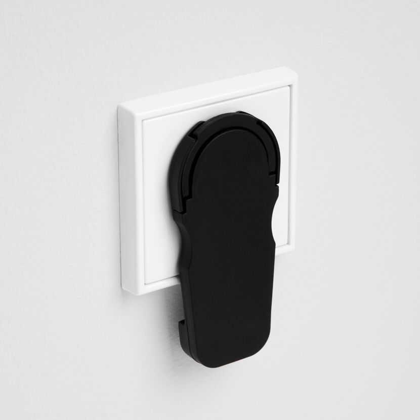 Schwarzer Winkelstecker an weißer Steckdose