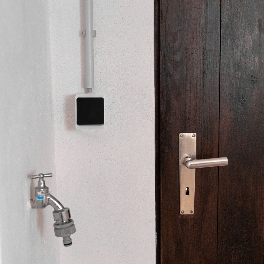 AP Wechselschalter IP54 Aqua Mini, Wasserhahn und Türklinke an weißer Wand