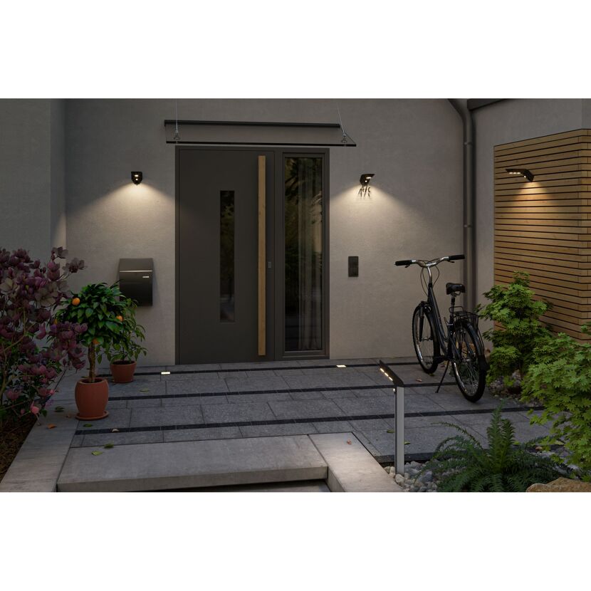 Beleuchtete Hausfassade mit Fahrrad.