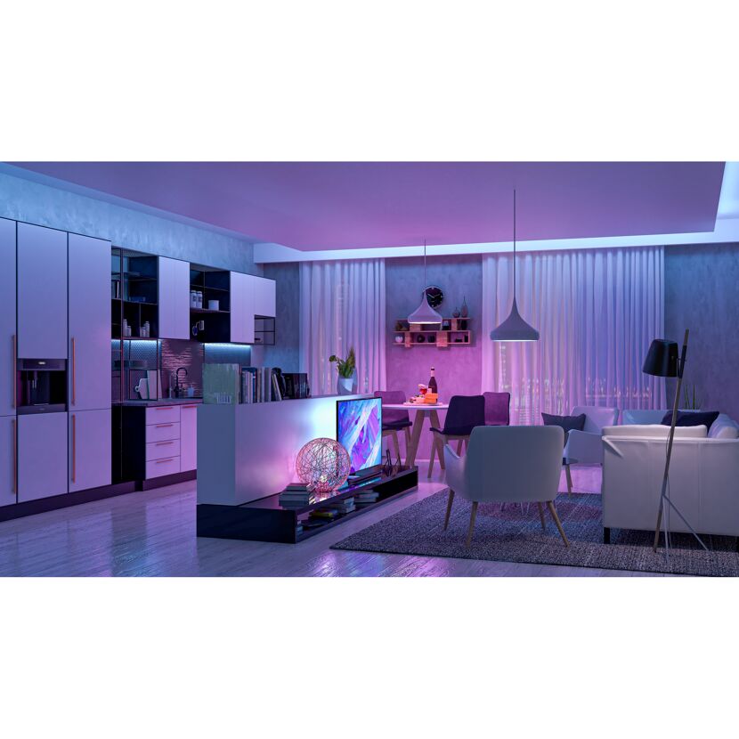 Modernes Wohnzimmer mit integrierter Küche und violetter Beleuchtung.