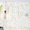 Glühbirne mit Kabel an gold-weißer Wand
