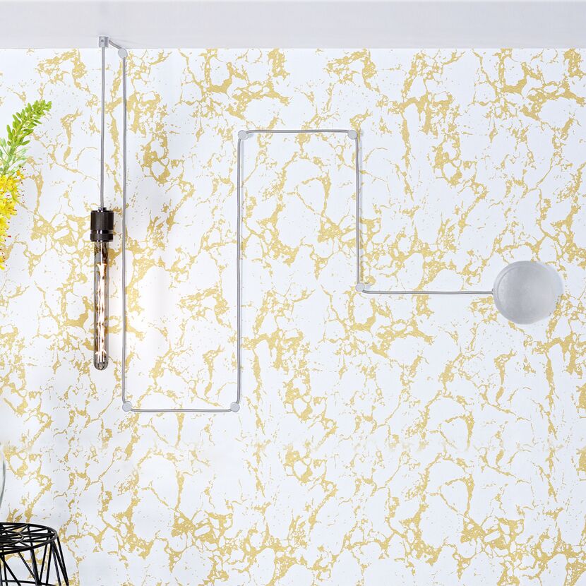 Glühbirne mit Kabel an gold-weißer Wand