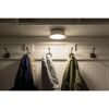 Weiße LED-Deckenleuchte leuchtet Garderobe mit Jacken aus.