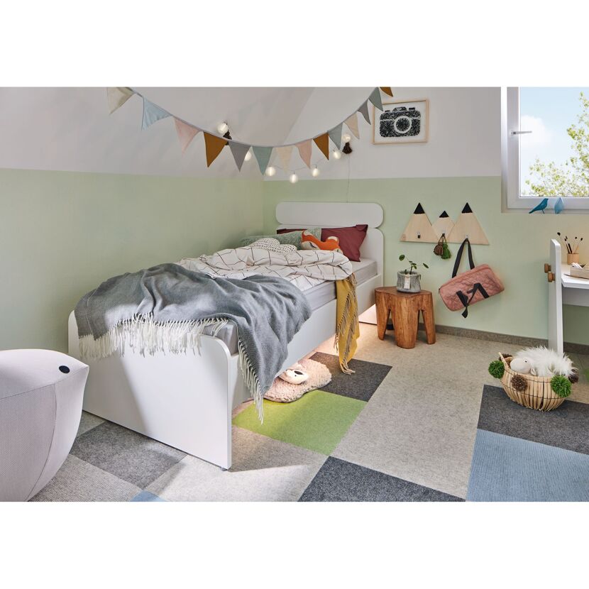 Kinderzimmer mit weißem Bett und Spielteppich