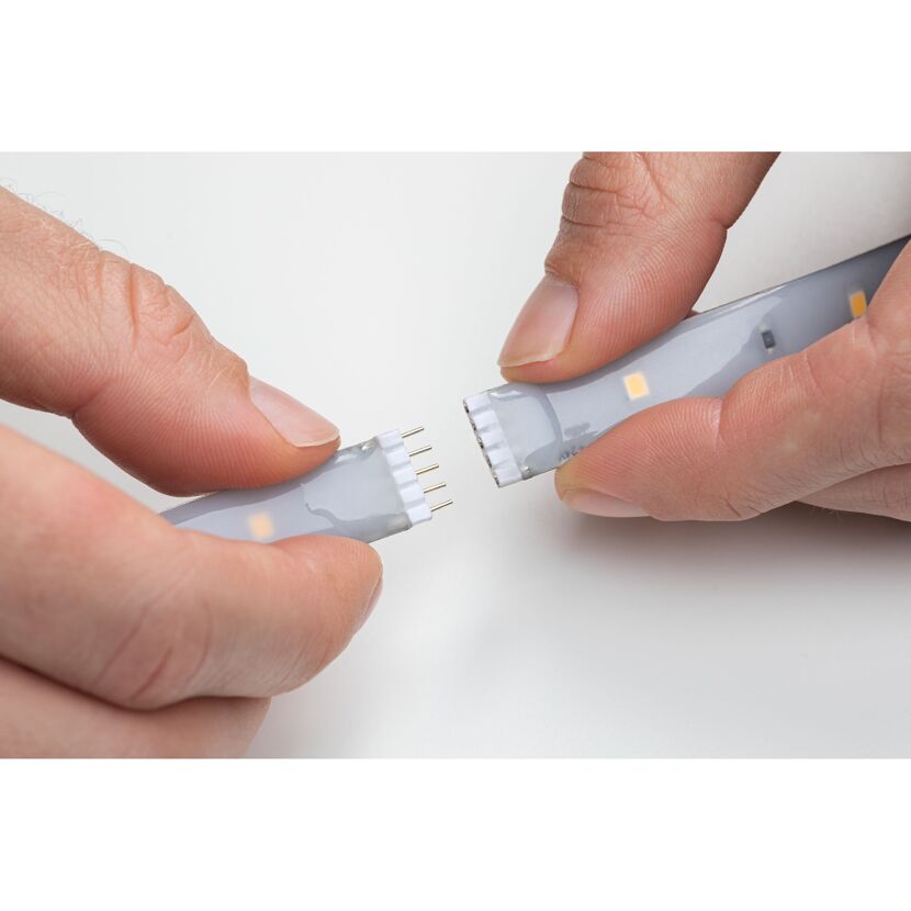 Zwei Hände trennen zwei LED-Streifen.