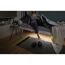 Person steht am Bett auf, unter dem Bett leuchtet ein LED-Strip.