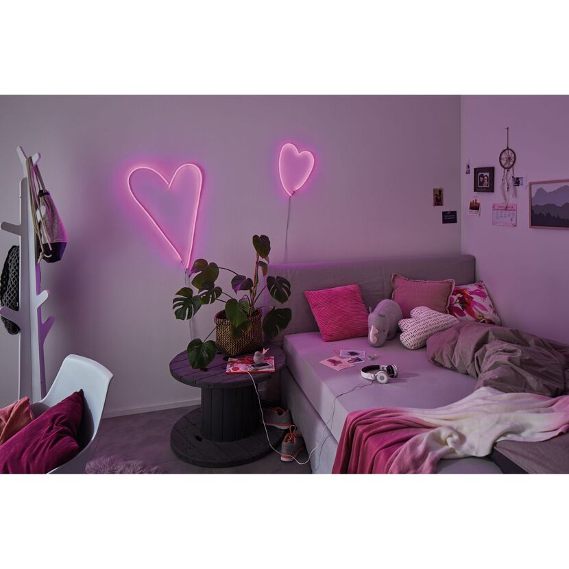 Schlafzimmer mit zwei pink leuchtenden Neon-Herz-Lichtern