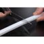 Person schneidet weißen LED-Strip mit Schere