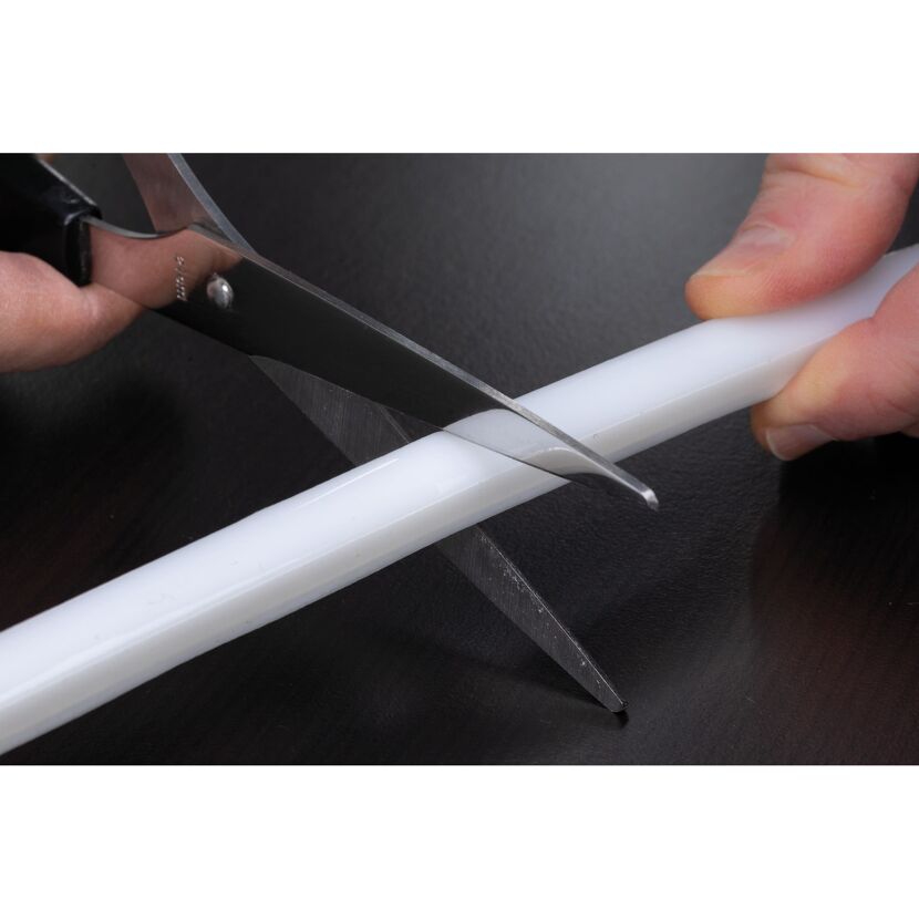 Person schneidet weißen LED-Strip mit Schere