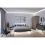 Schlafzimmer mit beleuchtetem Bett, Schrank und Sessel