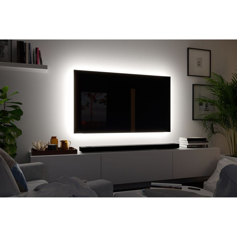 Beleuchteter Fernseher an der Wand in einem Wohnzimmer.
