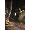 Person steht neben leuchtender Sockelleuchte