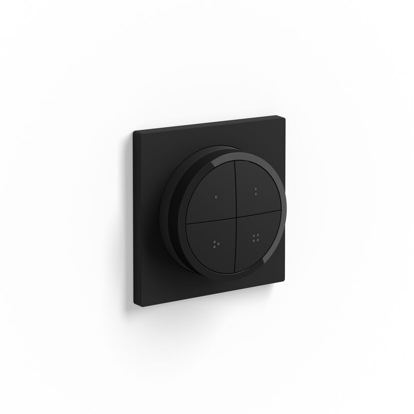 Schwarzer Funkschalter 'Hue Tap Dial' an weißer Wand.