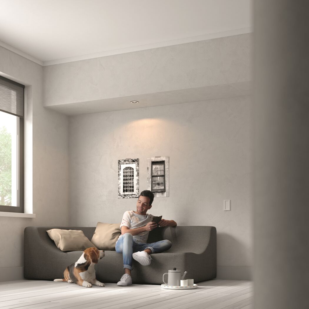 LED-Einbauspot 'Hue Milliskin' beleuchtet Wohnzimmer mit Person und Hund.
