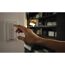 Hand bedient Philips Hue Dimmer an der Wand.