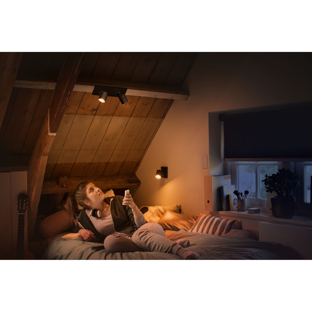 Person steuert LED-Spot 'Hue Runner' mit Fernbedienung.