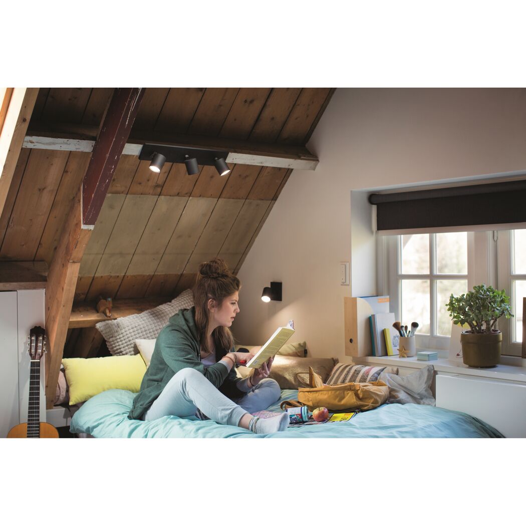 Person liest im Dachzimmer, beleuchtet von Hue Runner Spots.
