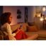 Person steuert Hue White LED-Leuchtmittel mit Smartphone.