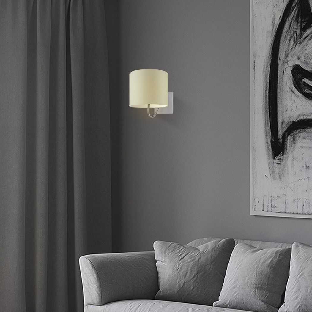 Beige Wandleuchte mit rundem Lampenschirm an grauer Wand.