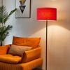 Rote Stehlampe neben orangefarbenem Sessel