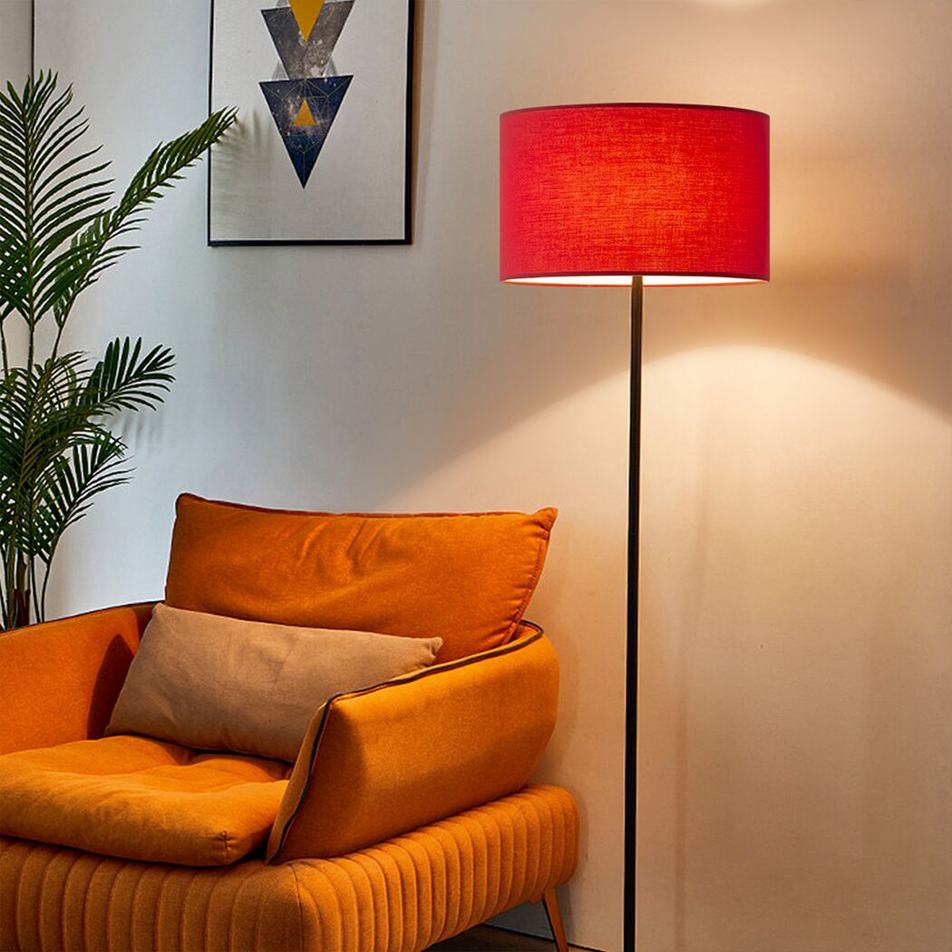 Rote Stehlampe neben orangefarbenem Sessel