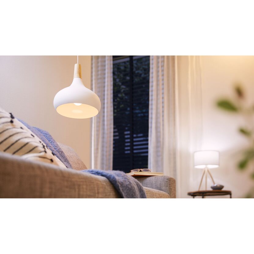 Hängelampe mit Holzfassung leuchtet über Sofa