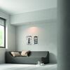 Gemütliches Wohnzimmer mit grauer Couch, Bildern und Teekanne
