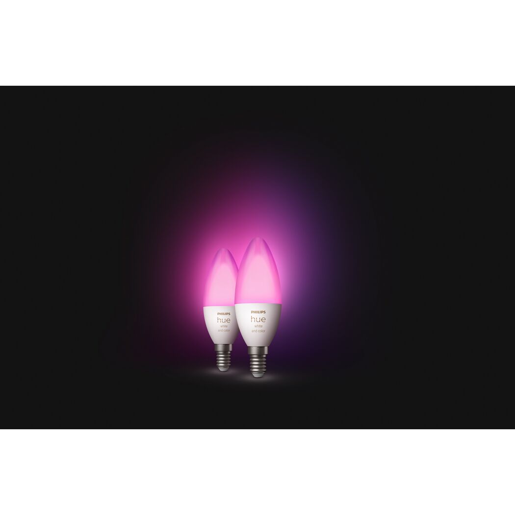 Zwei Philips Hue LED-Kerzenleuchtmittel leuchten pink.