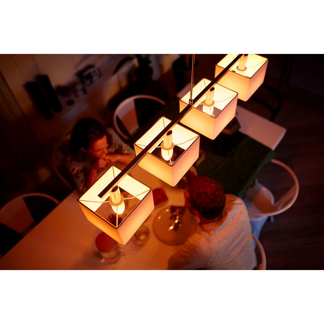 Esszimmer mit Personen unter dimmbarer 'Hue White' LED-Pendelleuchte.