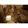 Warm leuchtende LED-Tischlampe im Wohnzimmer mit Sofa.