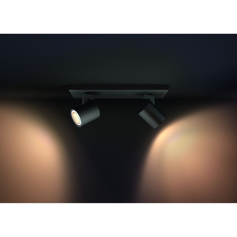 Zwei schwarze HUE Runner Spots beleuchten eine Wand.