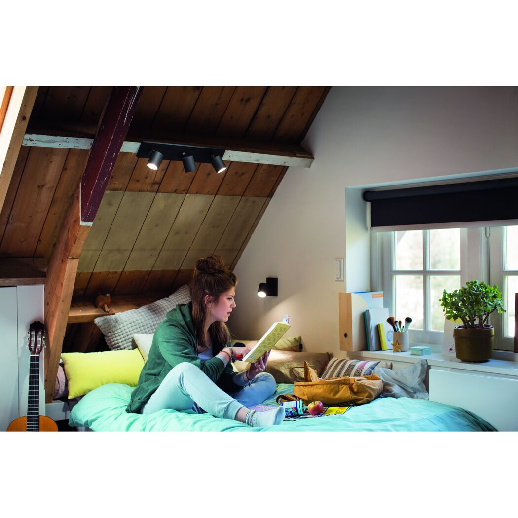 Person liest in einem beleuchteten Dachzimmer.